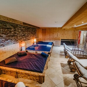 A room with two wooden beds, a brick wall, and a wooden ceiling.