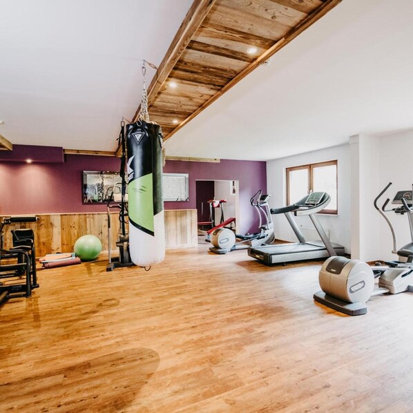 A gym with a punching bag, exercise equipment, and a treadmill.