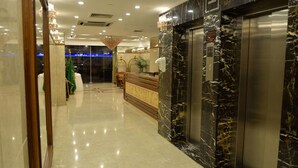 A hotel lobby with a marble reception desk, a reception area, and an elevator. - Al Hayatt Jeddah Hotel (Jeddah)