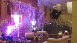 A wedding reception area with a floral backdrop, seating, and chandeliers. - Al Hayatt Jeddah Hotel (Jeddah)