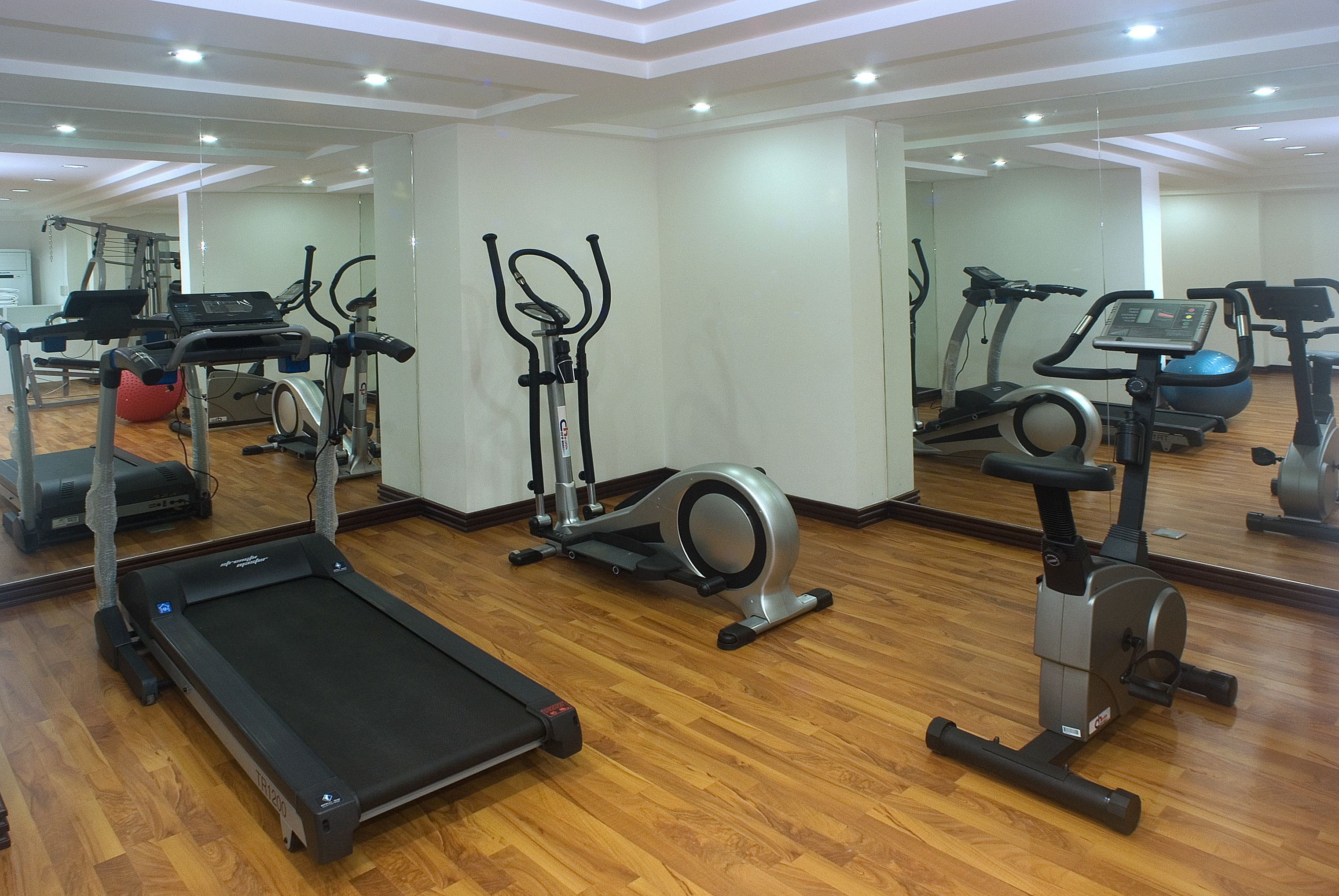 Un gimnasio con cinta de correr, elíptica y bicicleta estática.
