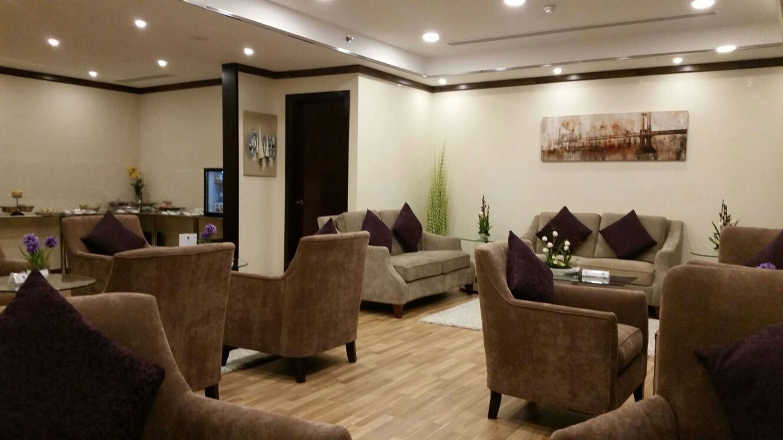 Un espacio lounge moderno con sofás y sillones distribuidos alrededor de una mesa de centro.