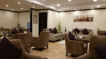 Un espacio lounge moderno con sofás y sillones distribuidos alrededor de una mesa de centro.