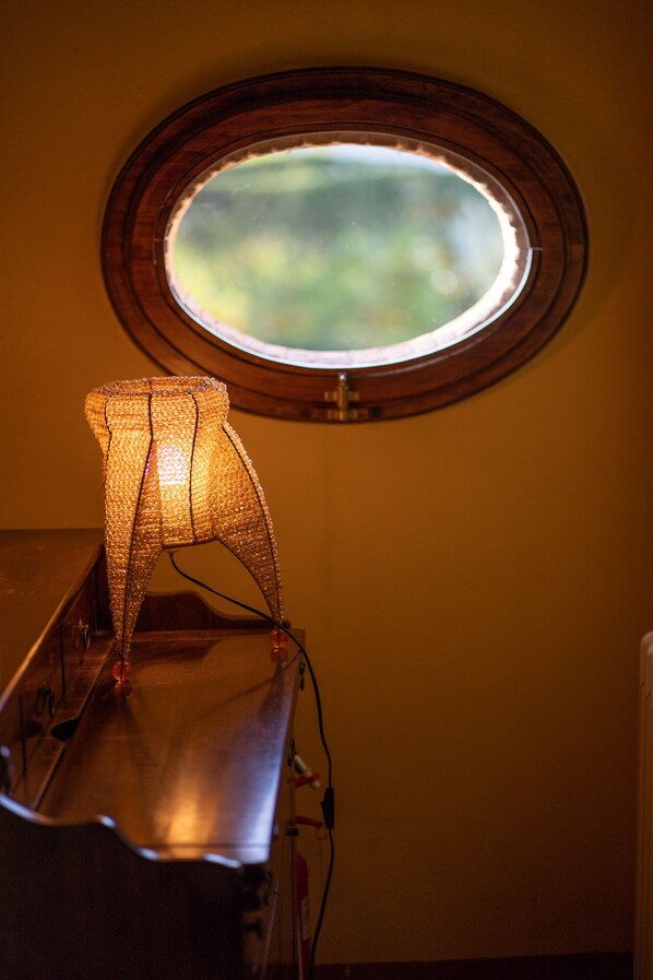 A room with a small window, a lamp, and a radiator.