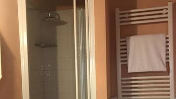 A bathroom with a shower, a toilet, and a towel rack.