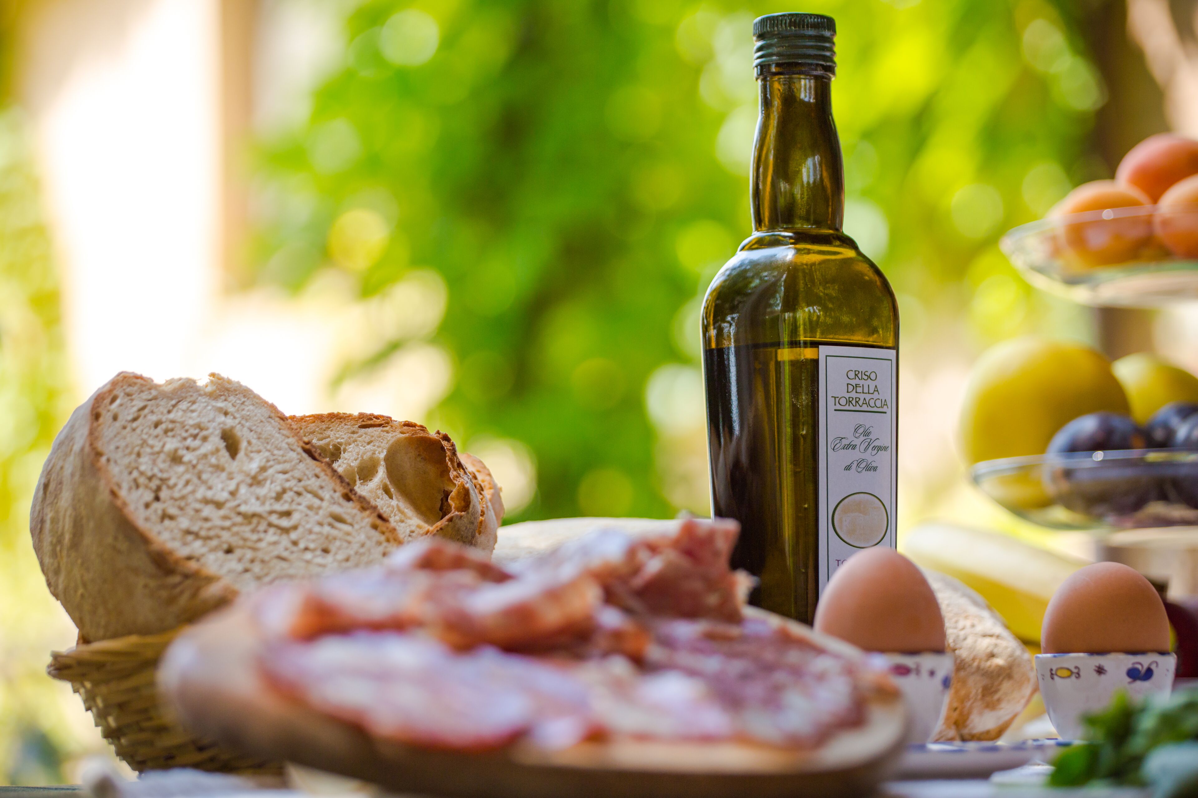 Ein Tisch mit Brot, Eiern und einer Olivenölflasche.