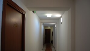 A narrow hallway with a wooden door marked "402" and a tiled floor. - Hotel Marina Victoria (Algeciras)