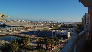 A coastal cityscape with a marina, a bridge, and a modern building with a white facade. - Hotel Marina Victoria (Algeciras)