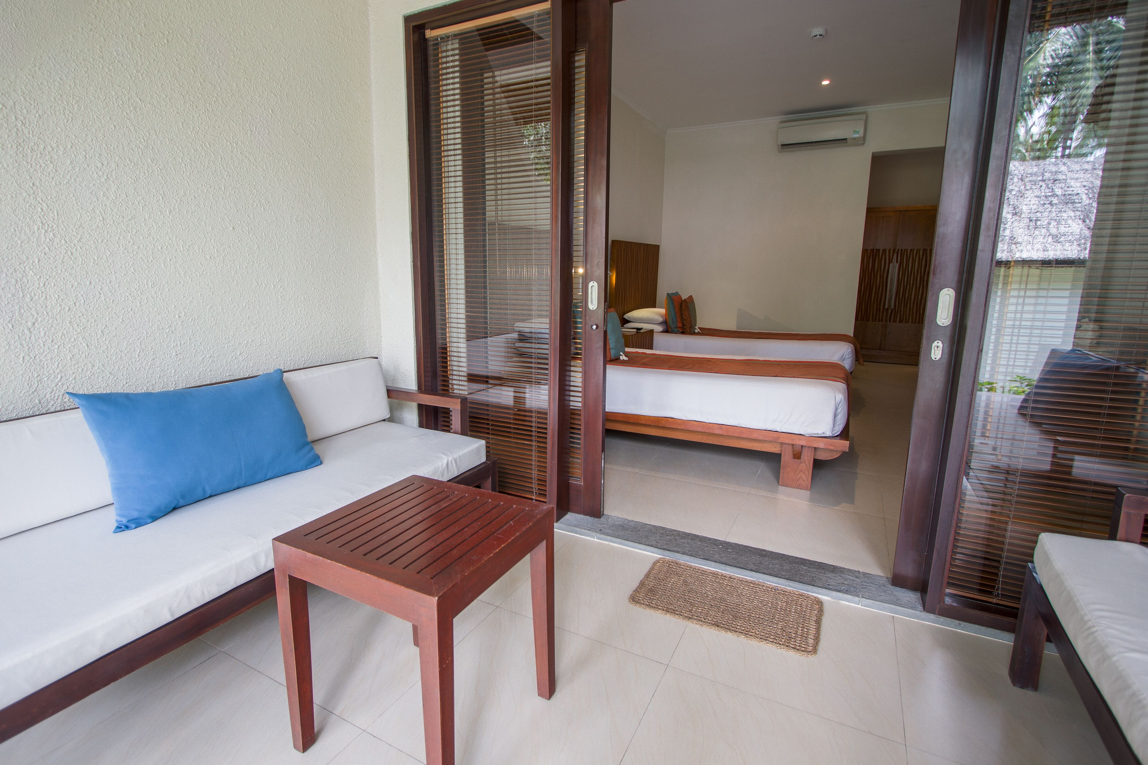 Una habitación de hotel con sofá, mesa de madera y cama.
