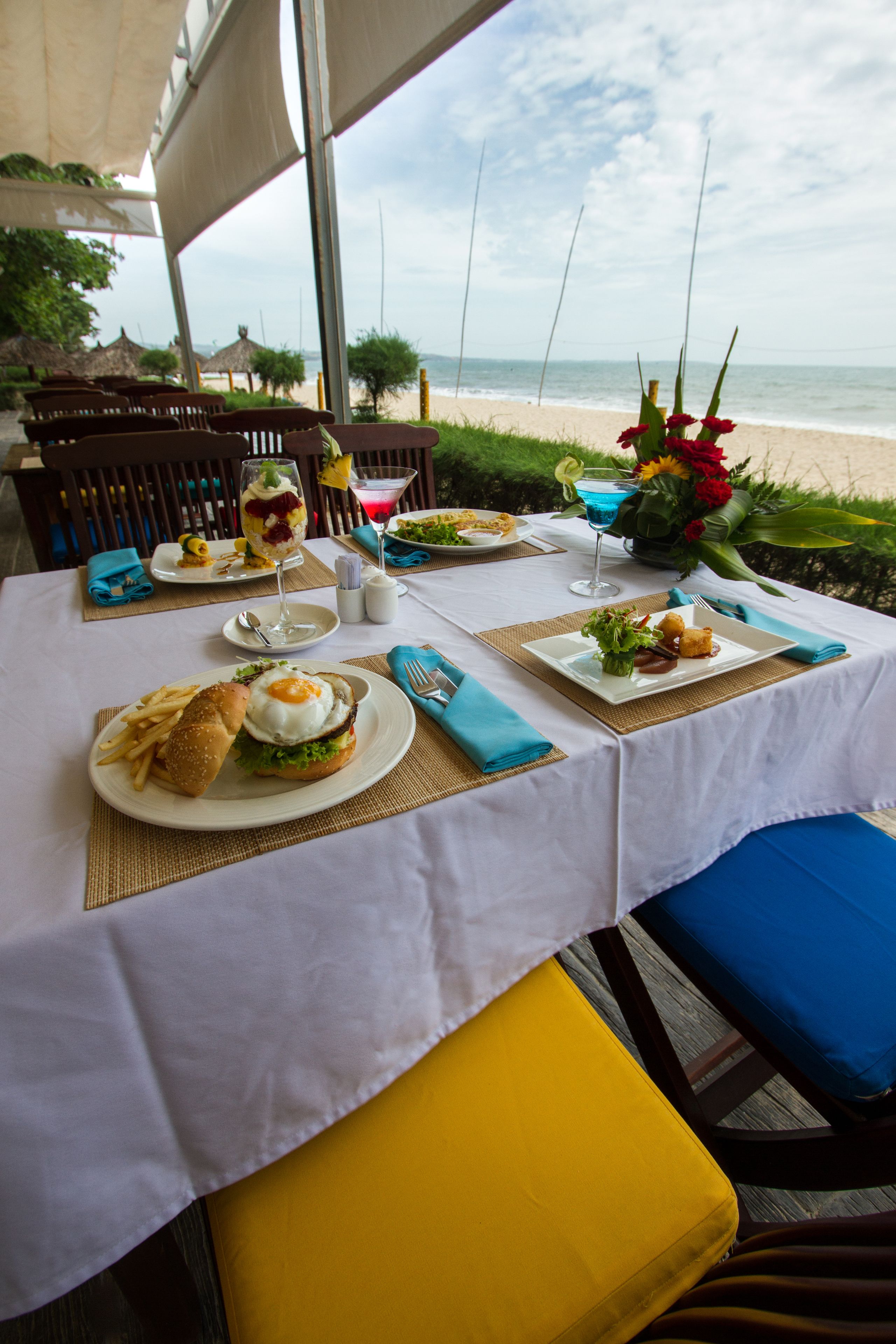 A table set for a meal with a view of the beach.