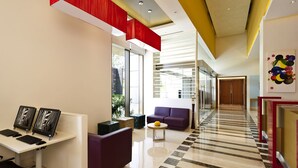 A modern lobby with a checkered floor, a reception desk, purple seating, and a glass partition. - ibis Nashik Hotel (Nashik)