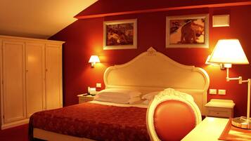 Ein Hotelzimmer mit einem großen Bett, einem Nachttisch, einem Schreibtisch und zwei Wandlampen.