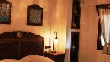 Une chambre à coucher avec un grand lit, une tête de lit en bois, une table de chevet avec une lampe et un luminaire au plafond.
