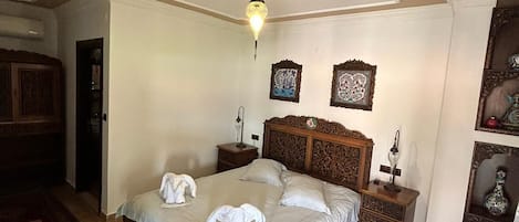Un dormitorio con cama de madera, mesita de noche, cómoda y lámpara en el techo.