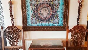 A traditional wooden cabinet with intricate carvings, a glass top, and a patterned back panel. - Hotel Nilya - Special Class (Selçuk)