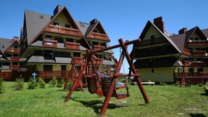 A residential area with multiple houses featuring steeply pitched roofs and balconies. - VISITzakopane Rainbow Apartments (Zakopane)