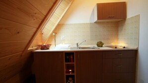A compact kitchen with a wooden countertop, a sink, and a small cabinet. - VISITzakopane City Apartments (Zakopane)