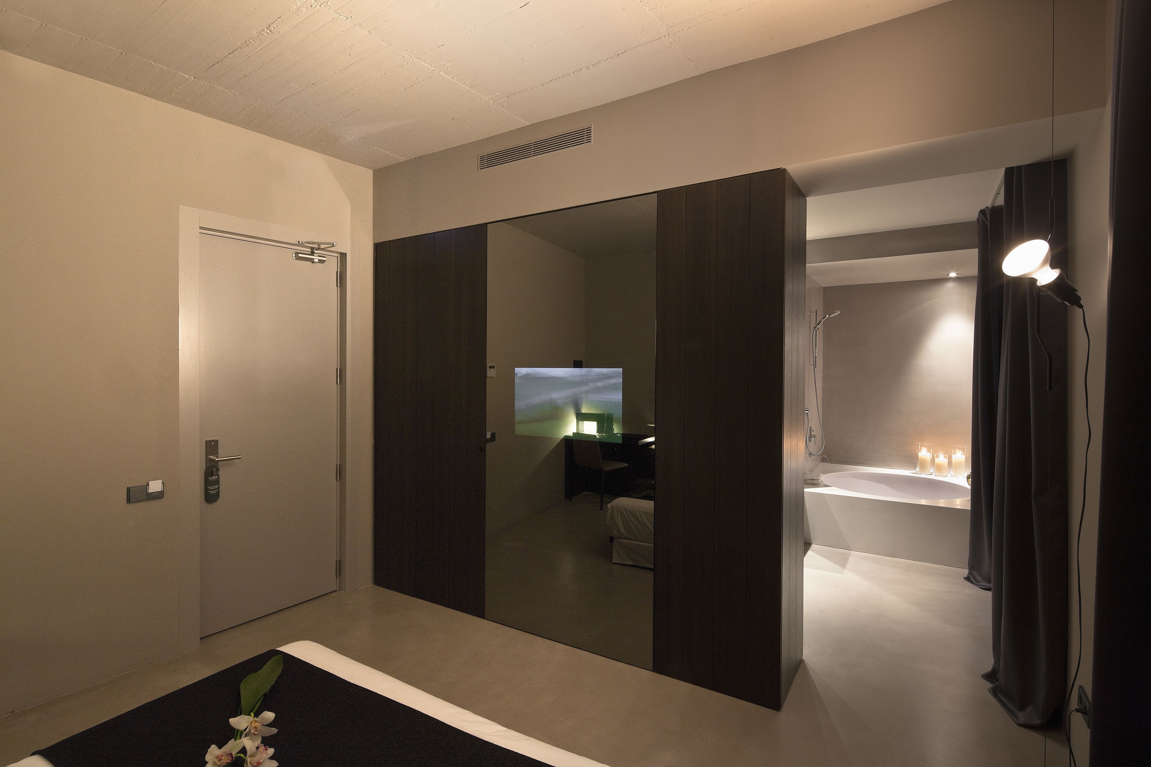 Une salle de bain moderne avec un grand miroir, une baignoire et une douche.