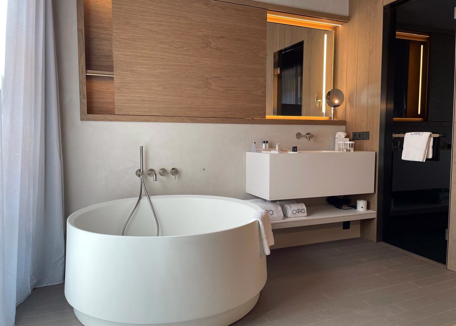 A modern bathroom with a freestanding bathtub, a vanity with a mirror, and a towel rack.