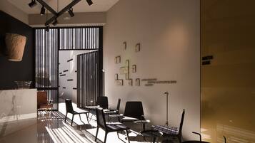 A modern interior with a reception desk, seating area, and artwork on the walls.