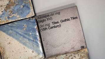 A close-up of a tile with text describing its origin and period.