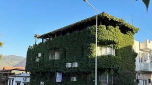 Un bâtiment portant une enseigne indiquant qu’il s’agit d’un hôtel, entouré d’un pavage en pierres.