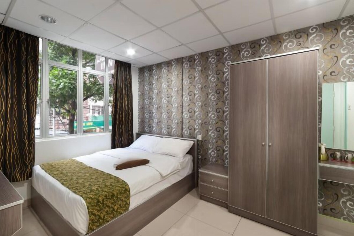 Een slaapkamer met een bed, een kledingkast, een raam en een badkamer.