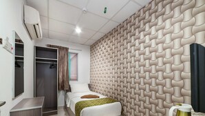 A modern hotel room with a bed, a wardrobe, a vanity, and a decorative wall panel. - LaComme Inn (Kuala Lumpur)