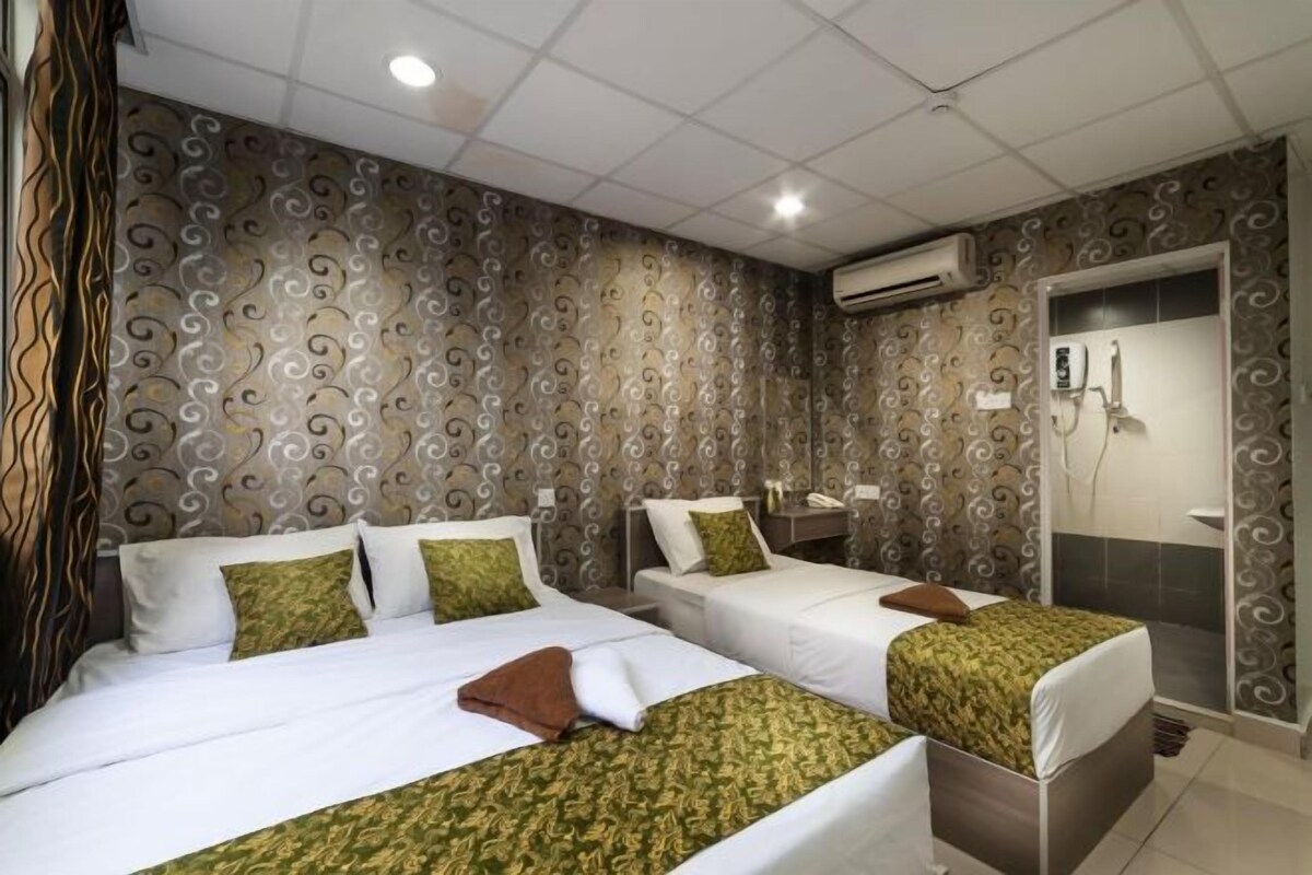 A hotel room with two beds, a shower, and a patterned wall.