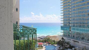 A high-rise hotel with a view of the ocean and a pool area.