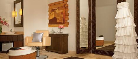 A modern bathroom with a large mirror, a sink, a vanity, a chair, and a robe stand.