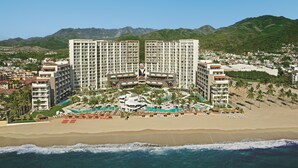 A resort with multiple high-rise buildings, a beachfront, and a pool area.