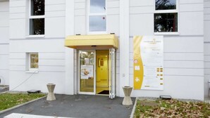 A white building with a yellow awning and a sign that reads "PREMIERE CLASSE HOTELS". - Hotel Premiere Classe Pau EST Bizanos (Bizanos)