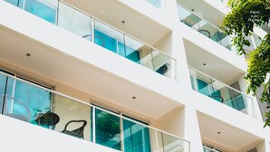 A multi-story building with balconies and large windows.