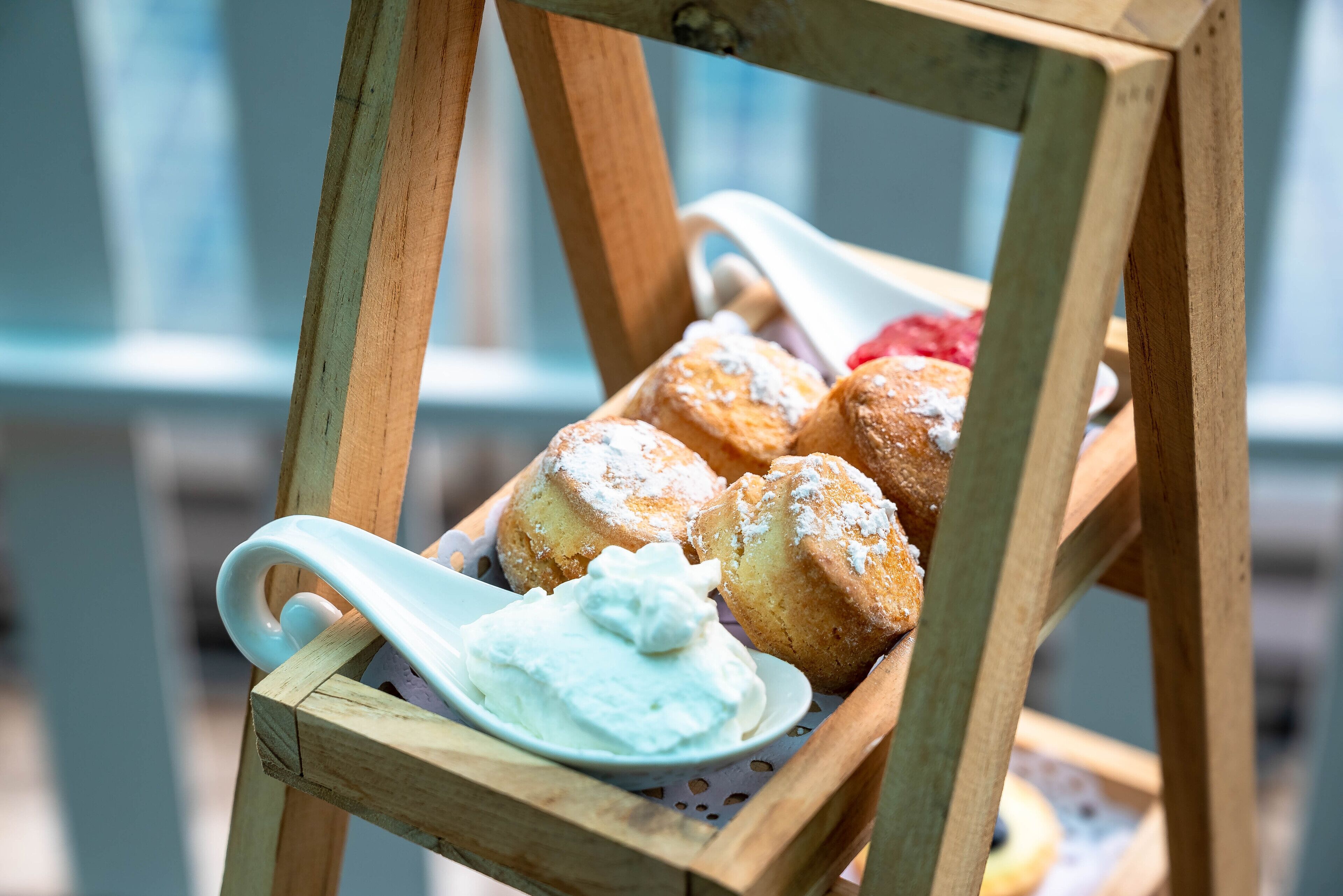 A wooden stand with pastries and a dollop of cream.