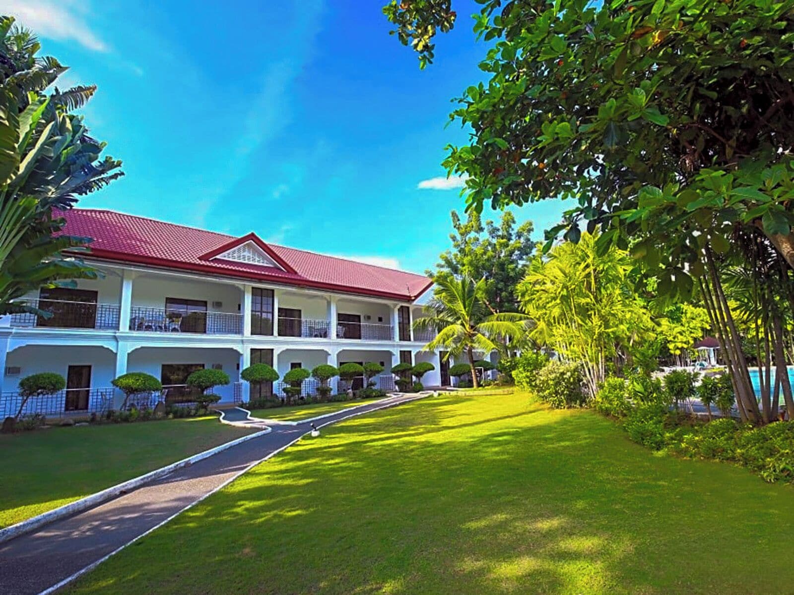 A two-story building with a red roof, white walls, and a covered walkway.
