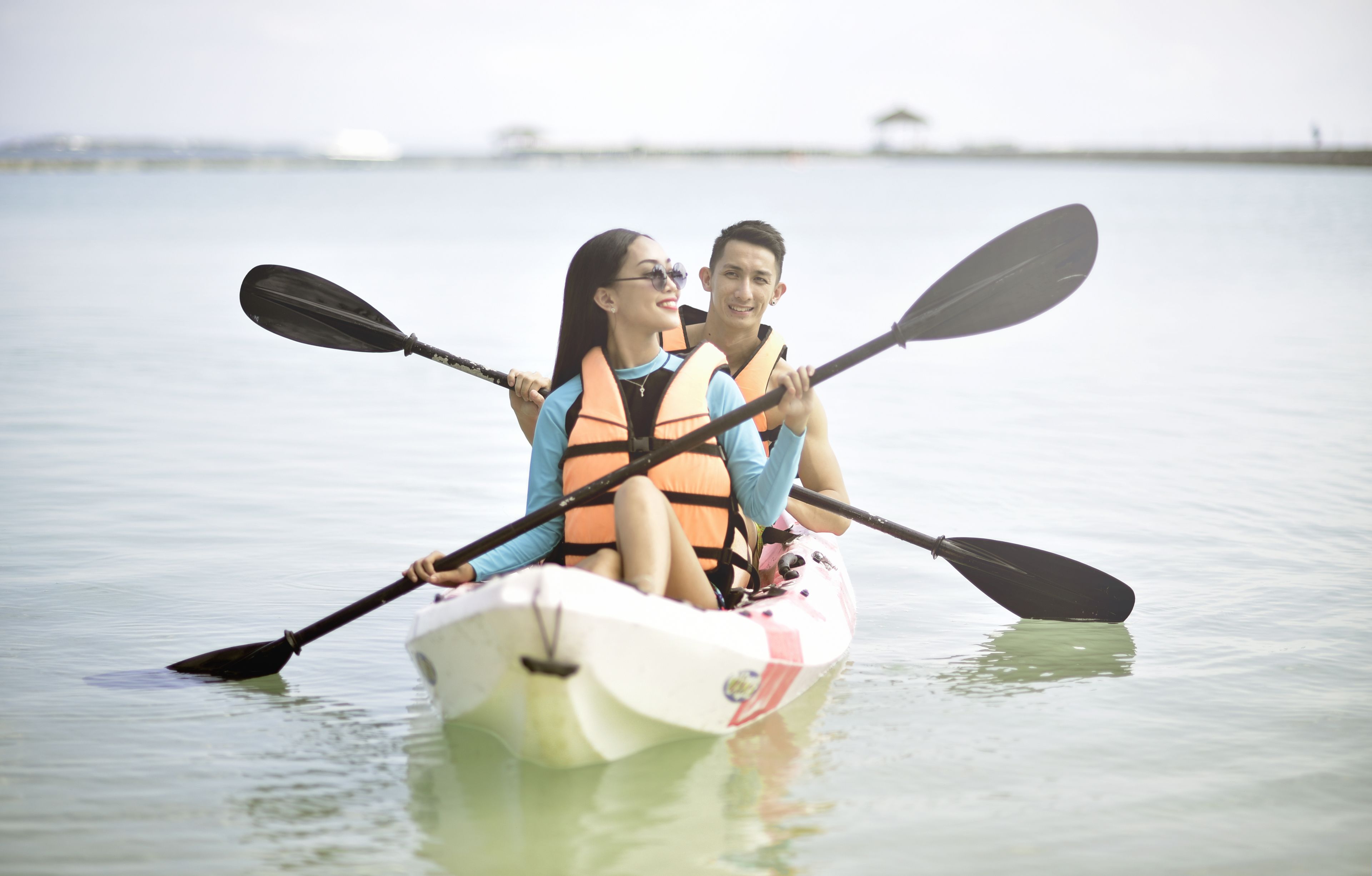 A couple in a kayak on calm water.