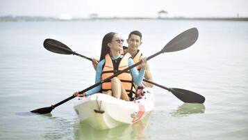 Una pareja en kayak sobre aguas tranquilas.