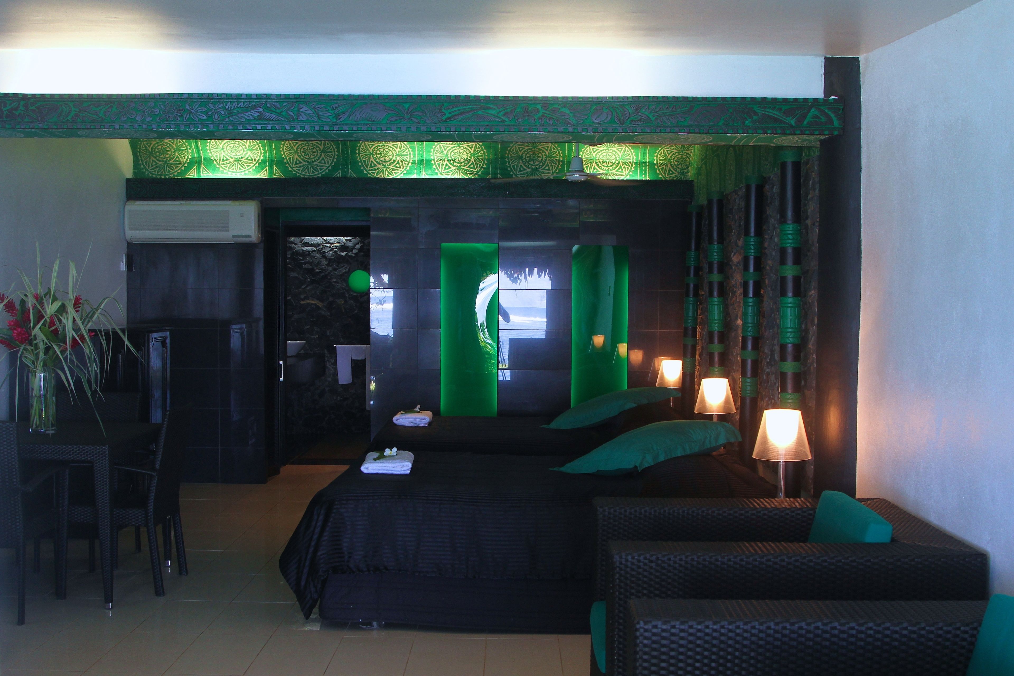 Habitación de hotel con dos camas, zona de comedor y vistas al exterior.
