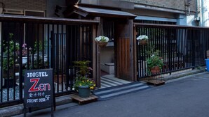 A hostel with a sign indicating a front desk and a 5F room. - Hostel Zen (Yokohama)