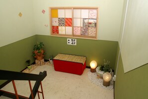 Una habitación pequeña y acogedora con un banco rojo, una ventana con vidrio decorado y un letrero que indica el nivel del piso.