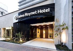 Exterior del hotel Daiwa Roynet, con fachada moderna, entrada y zona ajardinada.