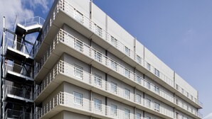A multi-story hotel with a modern architectural design, featuring balconies on each floor and a rooftop terrace. - Daiwa Roynet Hotel Sakaihigashi (Sakai)