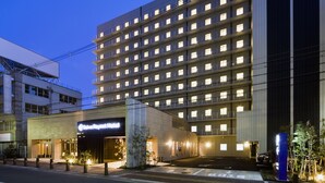 A multi-story hotel with a modern facade, illuminated windows, and a prominent entrance with a sign. - Daiwa Roynet Hotel Sakaihigashi (Sakai)