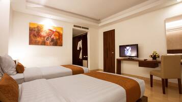 A hotel room with two beds, a desk with a TV, a chair, and a painting on the wall.