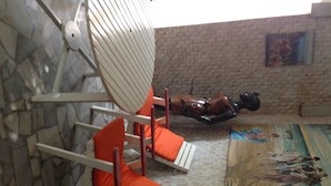 A room with a stone wall, a painting, and a sculpture. - Napoléon Aéroport (Lomé)