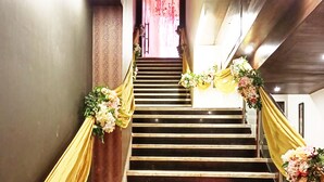 Una escalera adornada con cortinas amarillas y decoraciones florales.