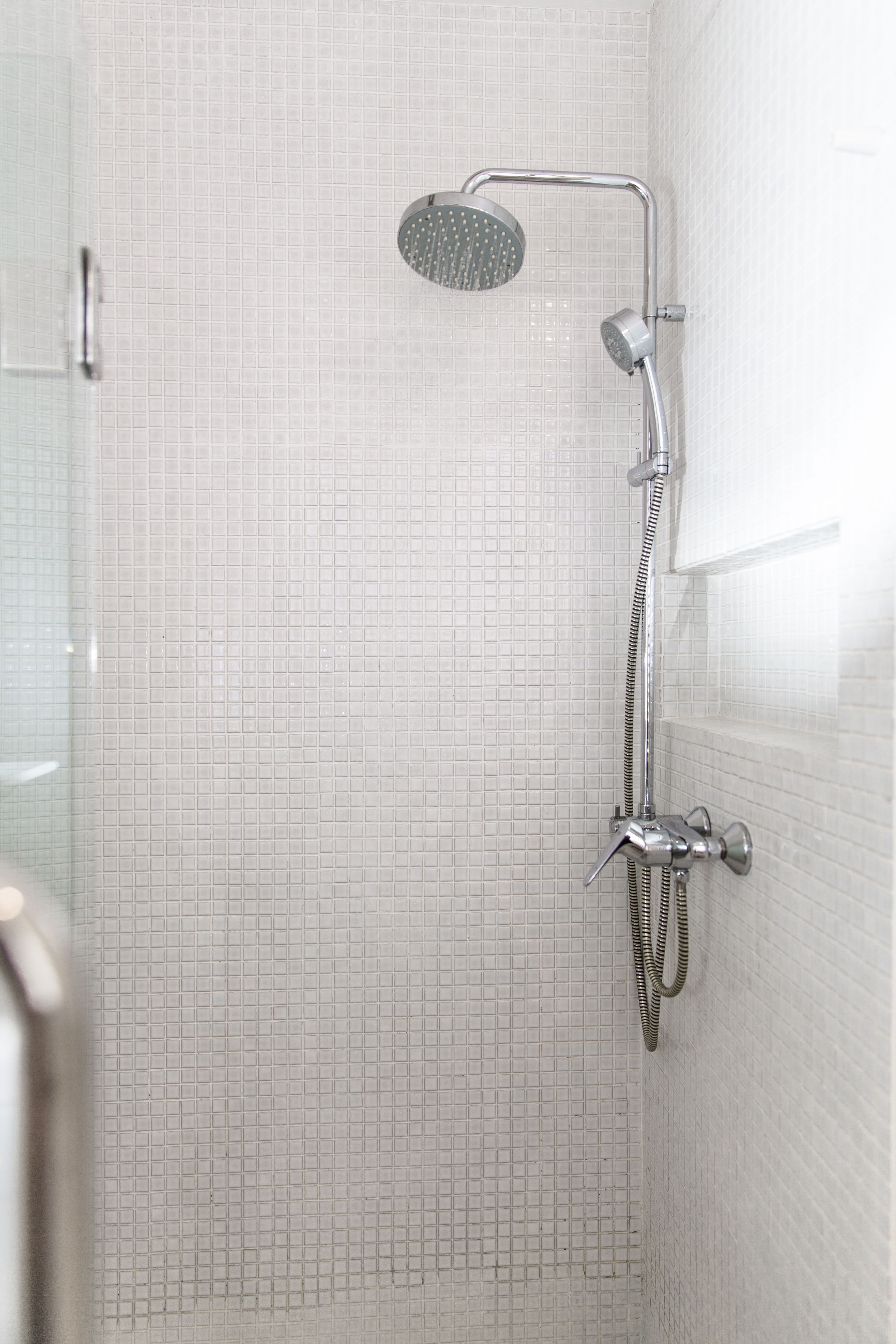 Ducha con cabezal de ducha de mano y grifo empotrado.
