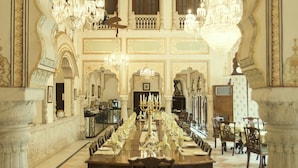 A grand dining hall with ornate chandeliers, a long table set for a meal, and intricate architectural details. - Alsisar Haveli - A Heritage Hotel (Jaipur)