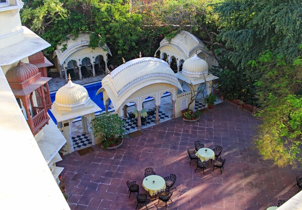 Un patio con piscina, mobiliario exterior y arquitectura tradicional.